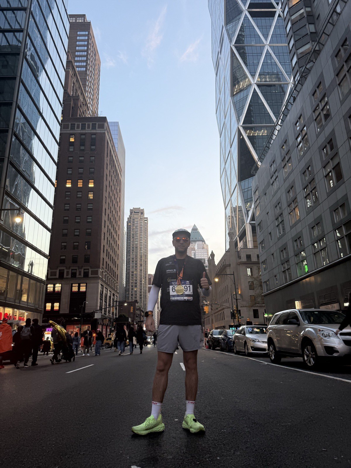 Dennis Hauptkorn nach dem NYC Marathon mit Medaille zwischen Manhattan-Hochhäusern